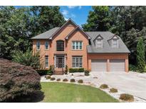 Charming two-story brick home features a well-manicured lawn and a three-car garage at 4062 Brookside Pkwy, Decatur, GA 30034