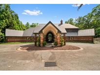 Stunning front view of home featuring circular drive, portico entrance, and lush landscaping at 114 Lees Lake Rd, Fayetteville, GA 30214