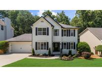 Charming two-story home featuring black shutters, a lush lawn, and well-maintained landscaping at 2688 Beddington Way, Suwanee, GA 30024