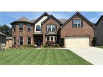Beautiful brick home featuring manicured lawn and mature landscaping at 4745 Belcrest Way, Cumming, GA 30040