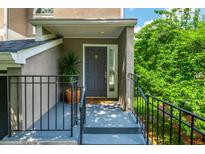 Inviting front entrance with black railings, steps, muted grey door with glass side panel, and greenery at 9 Saint Claire Ne Ln, Atlanta, GA 30324
