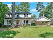 Charming two-story home with a well-manicured lawn and convenient covered parking at 1406 Arden Sw Dr, Marietta, GA 30008