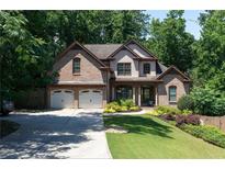 Charming two-story brick home featuring a well-manicured lawn and a two-car garage at 2015 Buford Dam Rd, Buford, GA 30518