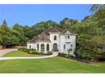 Beautiful two-story home with arched windows, lush landscaping, and a winding walkway at 510 Northland Ridge Ct, Sandy Springs, GA 30342