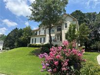 Charming two-story home featuring lush landscaping, a manicured lawn, and mature trees, creating inviting curb appeal at 600 Oakmont Hl, Duluth, GA 30097