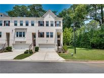 Charming townhome with white brick facade, attached garage, and well-manicured lawn at 1823 Lynwood Ln, Atlanta, GA 30329