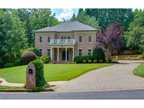 Beautiful two-story brick home with manicured lawn and circular driveway at 360 Hannaford Dr, Roswell, GA 30075