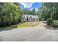 Charming two-story home with landscaped yard and mature trees on a sunny day at 186 Fernleaf Lane Ln, Marietta, GA 30068