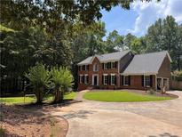 Beautiful brick home with a circular driveway and meticulously manicured lawn at 10560 Haynes Bridge Rd, Alpharetta, GA 30022