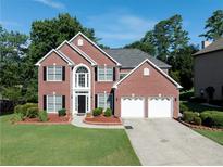 Beautiful two-story brick home with a two-car garage and well-manicured lawn at 10770 Glenhurst Pass, Duluth, GA 30097