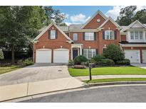 Charming brick home featuring a well-manicured lawn, two-car garage, and inviting curb appeal at 25 Hampreston Court Ct, Johns Creek, GA 30022