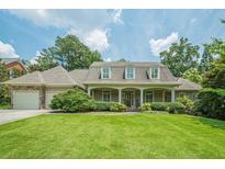 Traditional home featuring a manicured lawn, covered porch, dormer windows, and a side-entry garage at 2814 Tanner Lake Nw Trl, Marietta, GA 30064