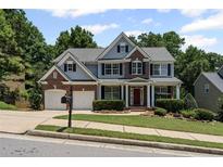 Charming two-story home with a well-maintained lawn, complemented by a two-car garage at 7090 River Island Cir, Buford, GA 30518