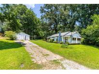Charming home featuring a well-maintained lawn, a driveway, and a detached garage at 1054 Hillcrest Se Dr, Atlanta, GA 30316