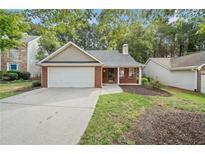 Charming brick home featuring a well-manicured lawn and attached two car garage at 172 Stoneforest Dr, Woodstock, GA 30189