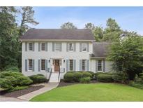 Charming two-story brick home with blue shutters, landscaped yard, and inviting front entrance at 1054 Foreststone Sw Way, Marietta, GA 30064