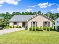 Charming brick home featuring a well-manicured front yard and gray shutters at 3260 Governors Court Ct, Duluth, GA 30096