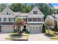 Charming townhome featuring gray siding, brick accents, a two-car garage, and a beautifully landscaped front yard at 109 Bellehaven Dr, Woodstock, GA 30188