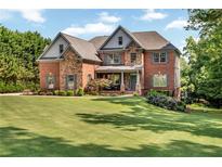 Beautiful brick two-story home with manicured lawn and tasteful landscaping at 7125 Heard Rd, Cumming, GA 30041