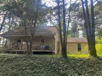 Charming home with a cozy front porch surrounded by lush greenery and mature trees at 245 Jesse Mccollum Dr, Canton, GA 30114