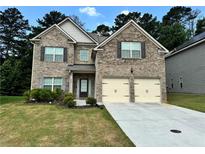 Charming brick two-story home with a manicured lawn and a two-car garage at 7487 Rudder Cir, Fairburn, GA 30213