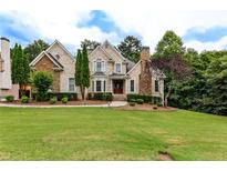 Beautiful two-story home with stone and brick facade, manicured lawn, and mature trees creating an inviting curb appeal at 1360 Mount Mickinley Dr, Grayson, GA 30017