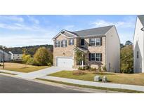 Inviting two-story home featuring a brick facade, a two-car garage, and a well-maintained front lawn at 1383 Van Allen Ct, Dacula, GA 30019