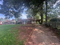 Charming single-story home with mature trees and a driveway leading to the carport at 1722 Donnalee Se Ave, Atlanta, GA 30316