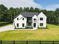 Stunning two-story home with a modern black and white exterior and a perfectly manicured lawn at 3207 Bold Springs Rd, Dacula, GA 30019