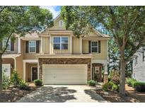 Charming townhome with a stone-accented facade, two-car garage, and well-maintained landscaping at 429 Mountain View Ln, Woodstock, GA 30188