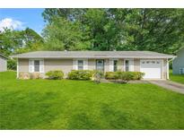 Charming one-story home with a well-manicured lawn and lush landscaping at 2454 Fairway Sw Cir, Atlanta, GA 30331