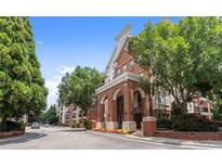 Charming brick apartment building featuring elegant archways, lush landscaping, and a welcoming entrance at 1850 Cotillion Dr Unit 3416, Atlanta, GA 30338