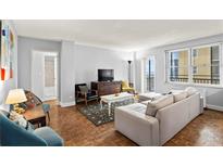 Bright living room features hardwood floors, large window, and comfortable seating arrangement at 300 Peachtree Ne St # 20 O, Atlanta, GA 30308