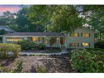 Charming two-story home with light green siding, shutters, mature trees, and landscaped front yard at 4669 Dunover Cir, Atlanta, GA 30360