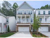 Charming home featuring a welcoming front porch, stone accents, and an attached two-car garage at 499 Bishop Ln, Woodstock, GA 30188