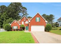 Charming two-story brick home with a well-manicured lawn and attached two-car garage at 3419 Allie Dr, Snellville, GA 30039