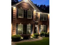 Charming brick home exterior, accentuated by stylish dark shutters and decorative outdoor lighting at 751 Stonecreek Way, Stone Mountain, GA 30087