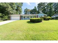 Charming one-story home featuring a lush green lawn and a brick and light blue facade at 4094 Colgate Way, Decatur, GA 30034