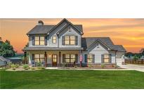 Charming two-story home with inviting front porch, shutters, green lawn, and an American flag at 1611 Alcovy Station Rd, Covington, GA 30014