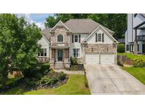 Charming two-story home with stone and siding exterior, landscaped front yard, and a two-car garage at 454 Pine Bluff Dr, Dallas, GA 30157