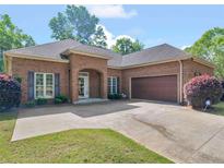 Charming brick home with a two-car garage, beautiful landscaping, and a well-maintained lawn at 570 Mcgarity Dr, Mcdonough, GA 30252