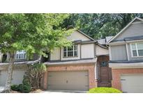 Charming townhouse featuring a two-car garage, brick accents, and mature trees at 109 Creighton Ln, Marietta, GA 30008