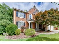 Charming brick home with a manicured front yard and mature landscaping creating great curb appeal at 457 Skiles Ct, Suwanee, GA 30024
