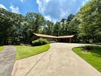 Charming home featuring a long driveway, mature trees, and well-maintained landscaping at 125 Cannongate Cir, Sharpsburg, GA 30277