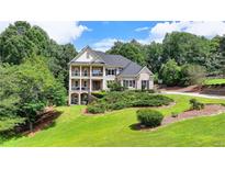 Elegant brick home with a manicured lawn, multi-level porches, and mature trees at 1867 Miramonte Way, Lawrenceville, GA 30045