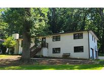 Charming white brick home with dark window frames and a lush green lawn at 3924 Devonshire Dr, Marietta, GA 30066