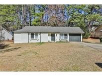 Charming single-story home featuring a neutral color, front lawn, and attached garage at 3915 Basil Sw Way, Atlanta, GA 30331