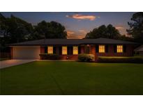 Charming brick home with a well-manicured lawn and inviting curb appeal at dusk at 3089 Ranlo Dr, Atlanta, GA 30340