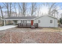 Charming single-story home featuring a carport, a cozy front porch, and a well-maintained yard at 3406 Blackberry Ln, Villa Rica, GA 30180