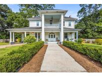 Stately two-story home featuring grand columns, a covered porch, and mature landscaping along the walkway at 205 Cobb St, Palmetto, GA 30268